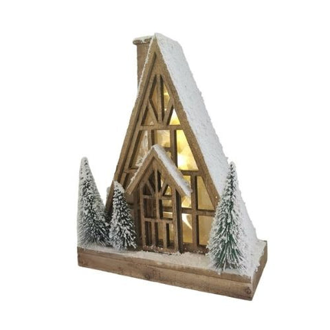 Chalet lumineux en bois avec sapins enneigés