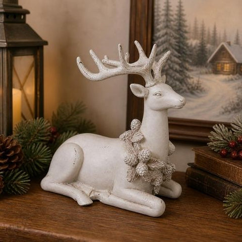 Cerf décoratif blanc couché avec pommes de pin